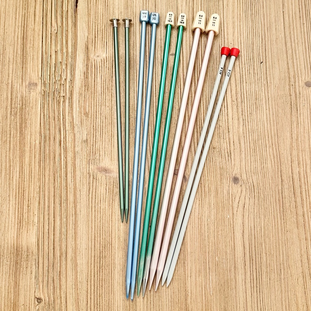 Bundle of 5 pairs of knitting needles in various sizes.